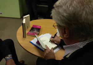 A. Selerowicz podpisujący książkę.